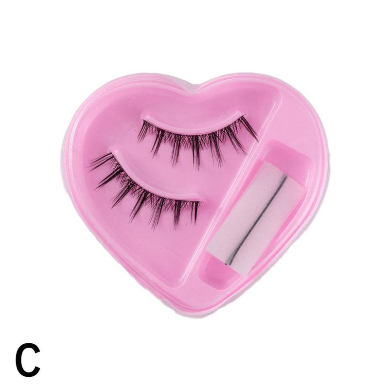 A pair of heart-shaped self-adhesive false eyelashes, natural, long, and thick, with adhesive strips.